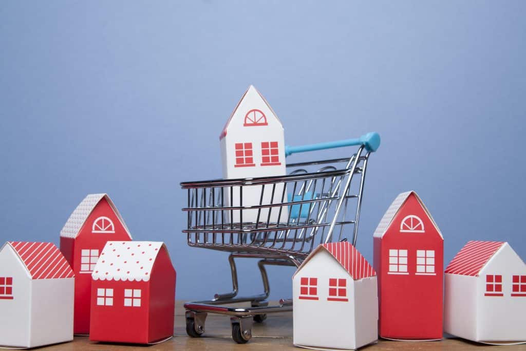 Buying a house concept. Model home in a shopping cart