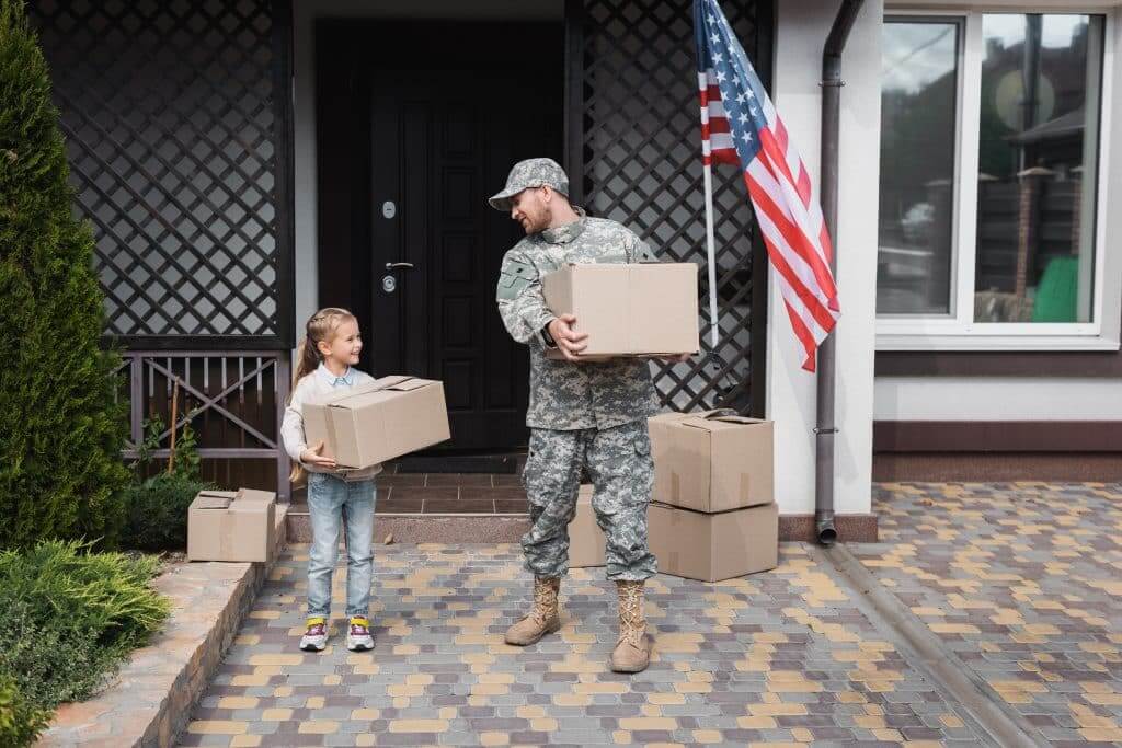 Father in military uniform and daughter holding cardboard boxes